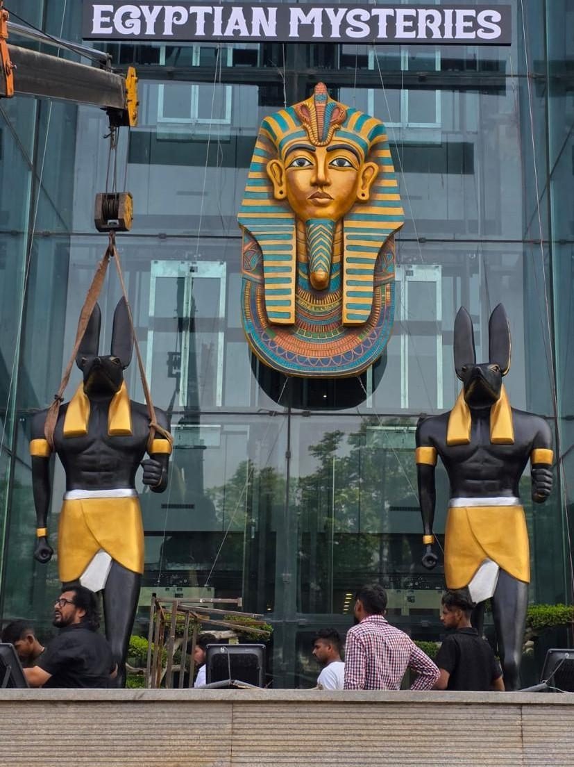 Egyptian-themed pharaoh and Anubis figures at a mall entrance