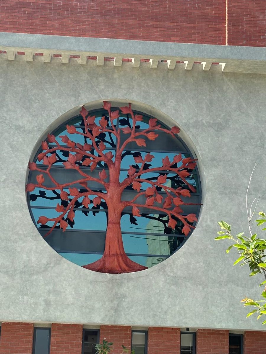 Circular tree-of-life metal screen on a building facade