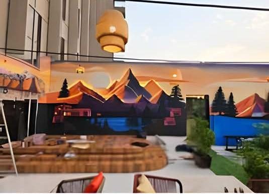 Illuminated mountain-themed wall mural in a café