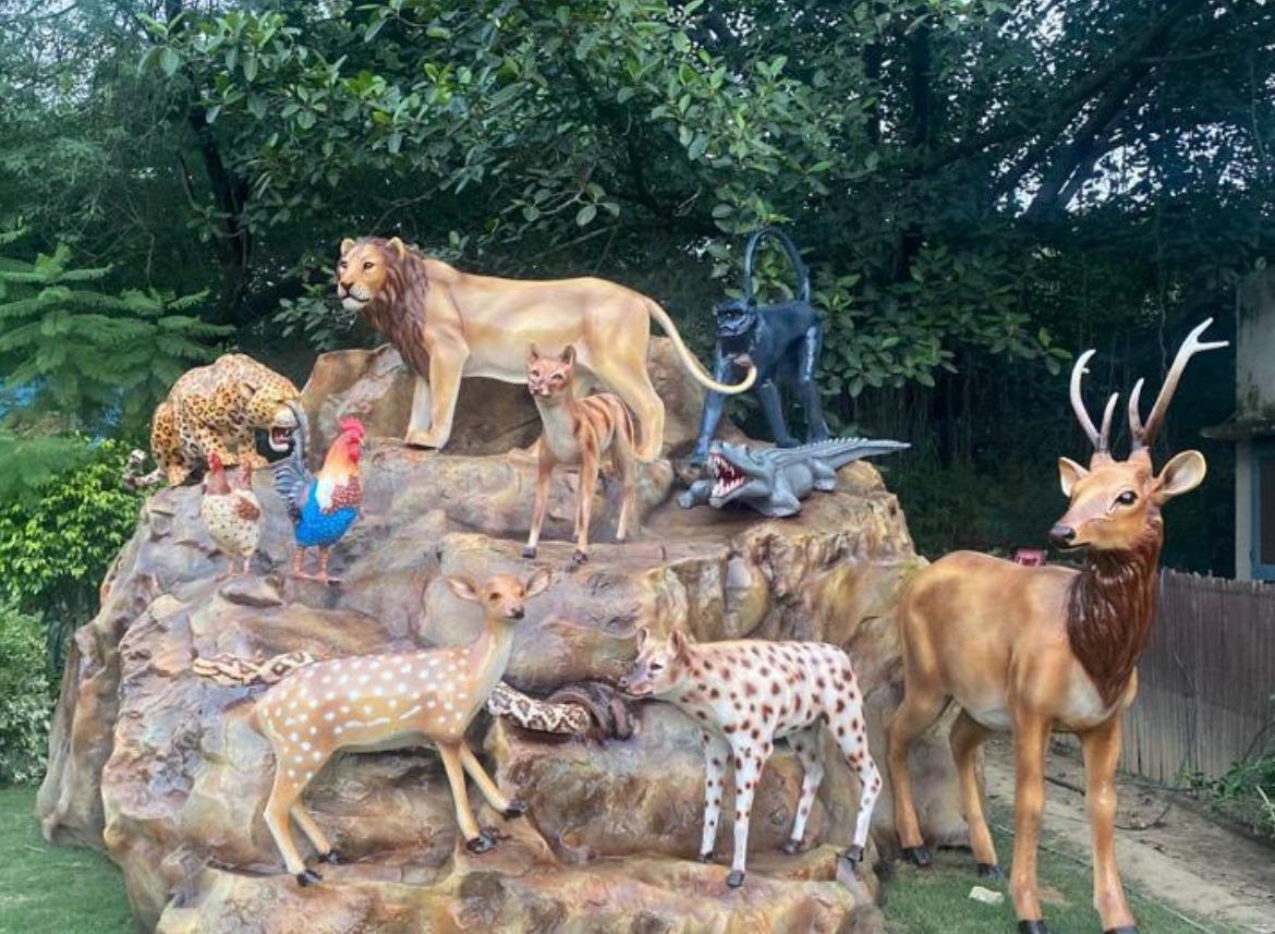 Wildlife diorama with life-size FRP lion, deer, leopard, crocodile and birds on an artificial rock